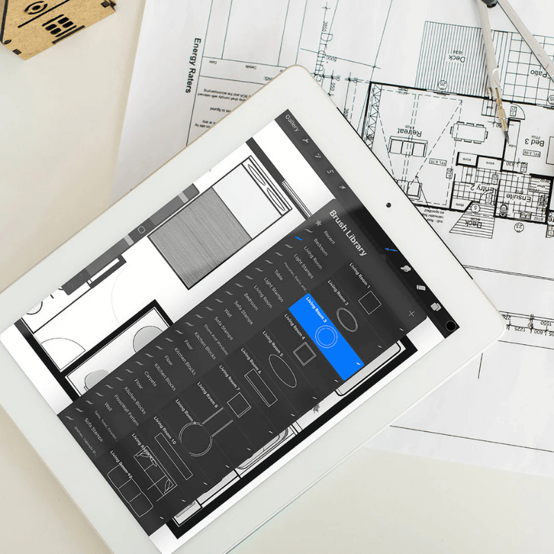 Tablet displaying architectural design software with blueprints in the background