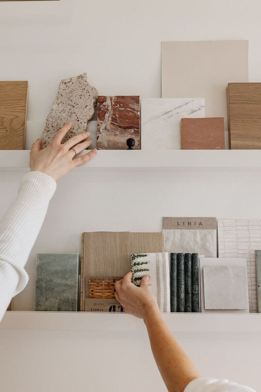Person selecting color swatches on a white surface