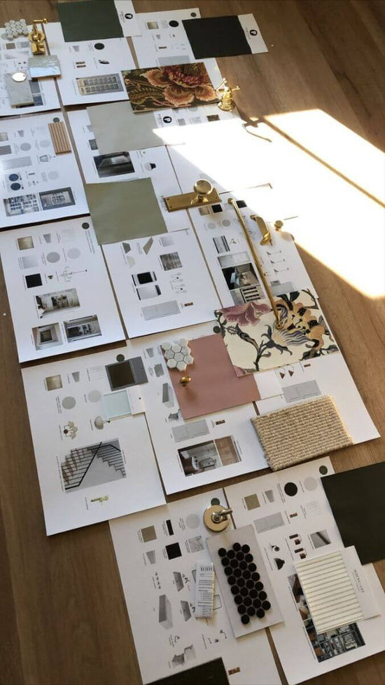 Collection of printed design elements on a wooden surface with a lamp.